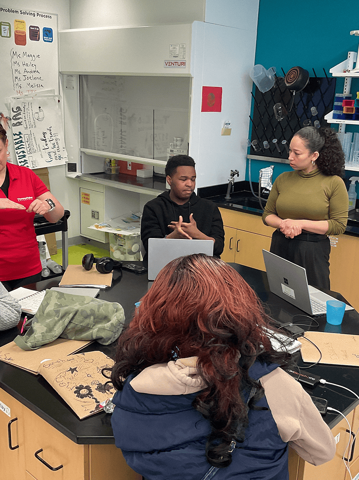 FirstHand students sitting around a table having discussion with a mentor